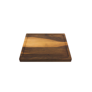 Medium sized handmade cutting board, in walnut, hand finished, with a carved, recessed face feature for juicy foods. Made in the USA.