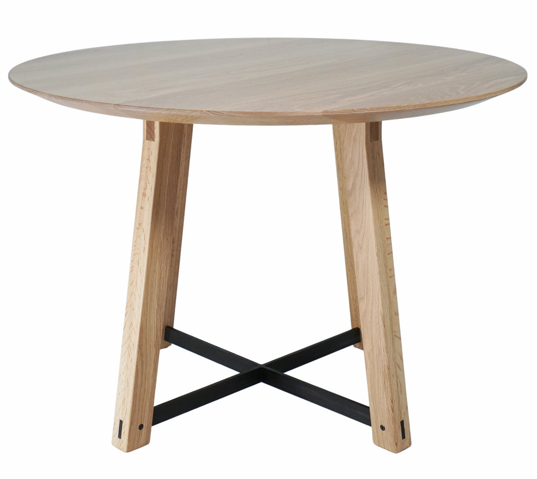 Modern round dining table. Handmade in the USA. With a tapered pedestal legs with blackened steel supports. Great for small spaces